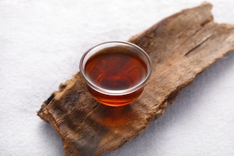a glass of tea sitting on top of a piece of wood