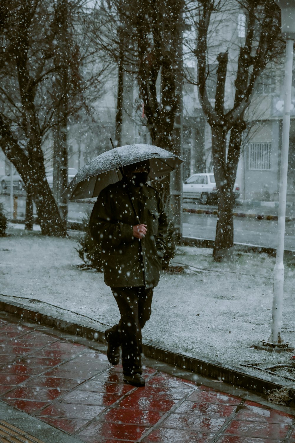 a person walking in the snow with an umbrella