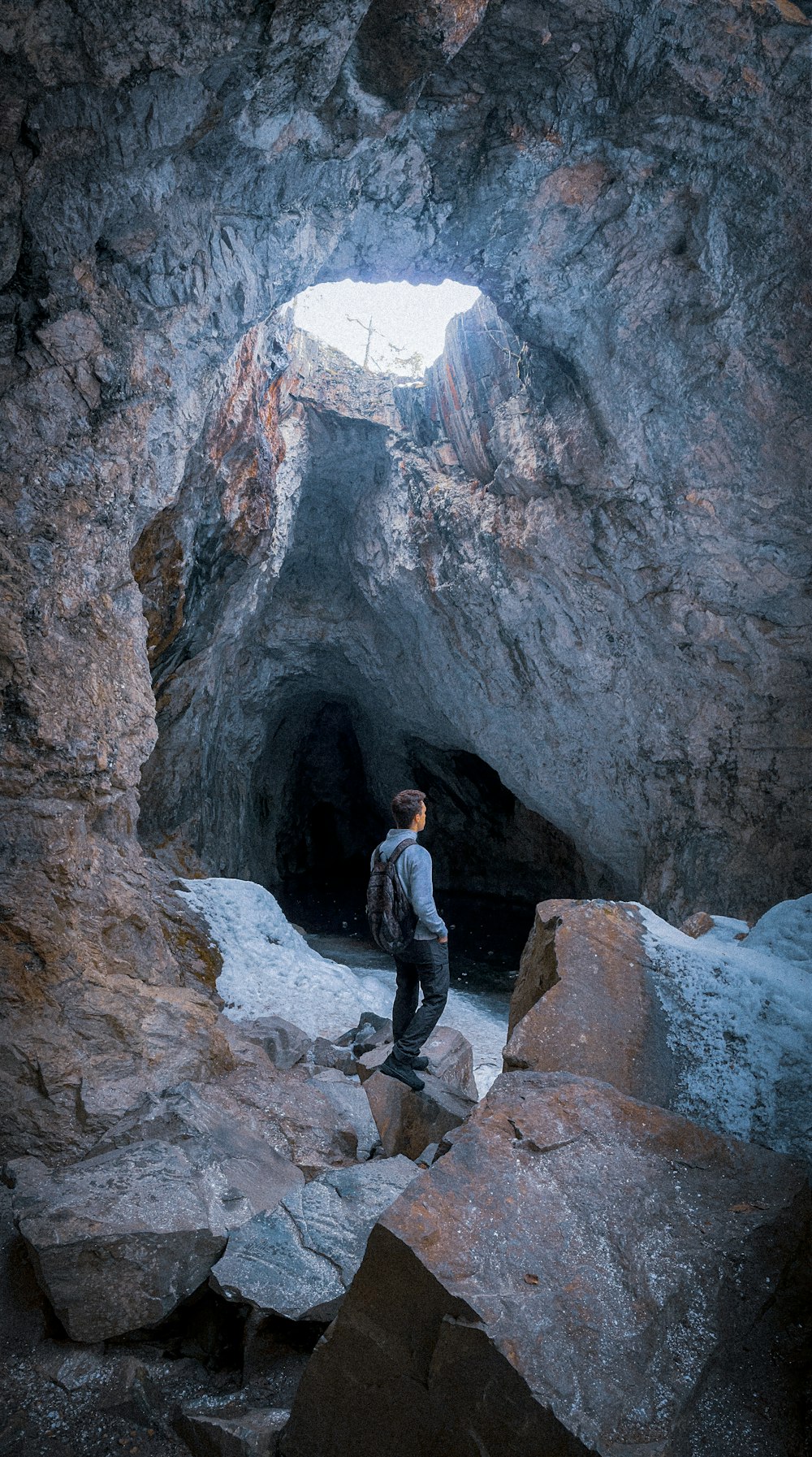 a man standing in a cave with a backpack