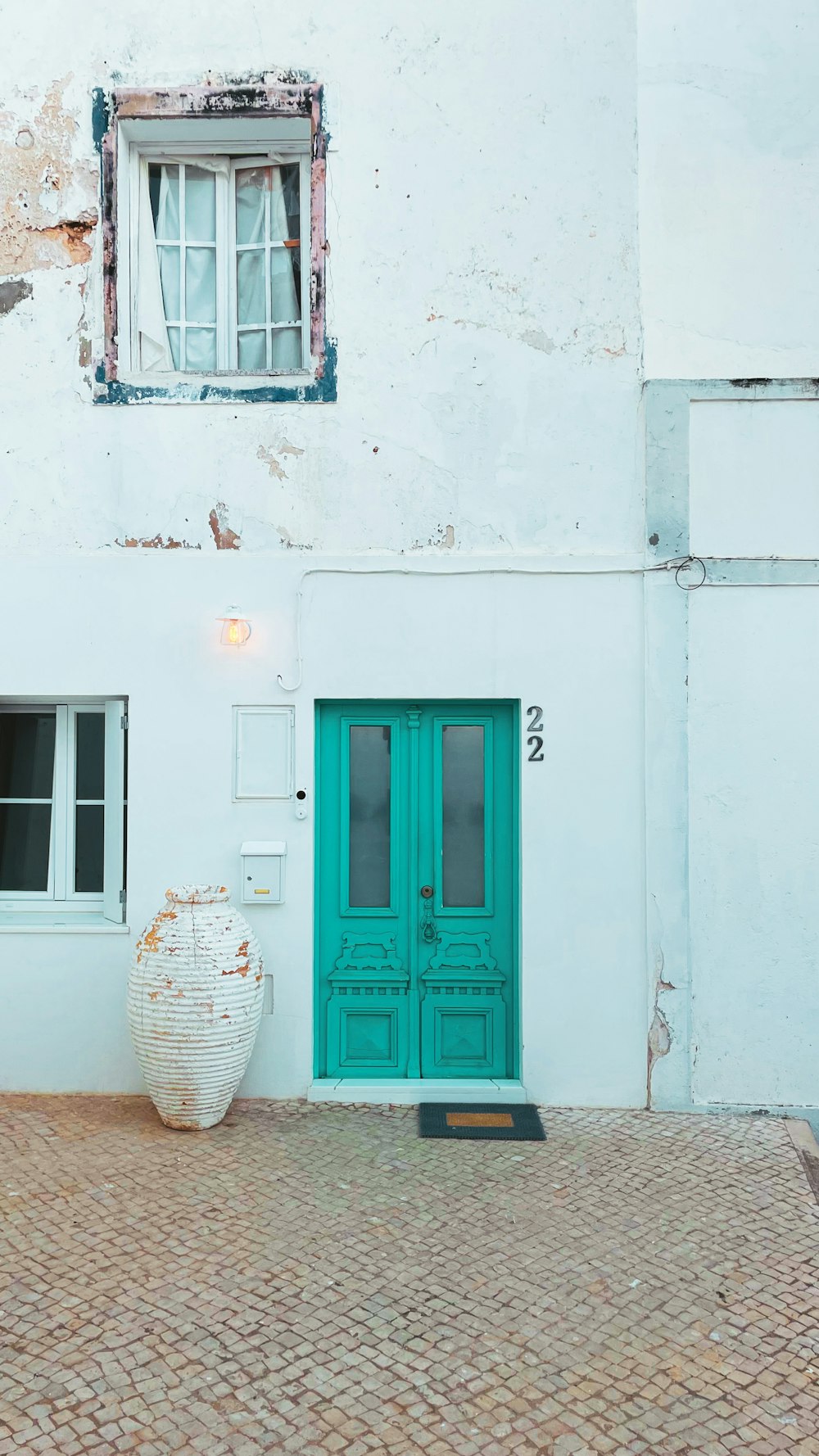 un bâtiment blanc avec une porte et une fenêtre vertes