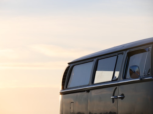 A sleek cargo van parked beside a highway at sunset, ready for delivery.