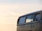 A sleek black and gold locksmith van parked in front of the iconic Saint Louis Gateway Arch at sunset.