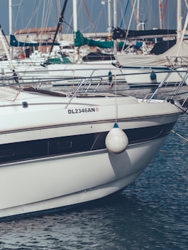 A marine surveyor inspecting a boat hull on a sunny dockside.