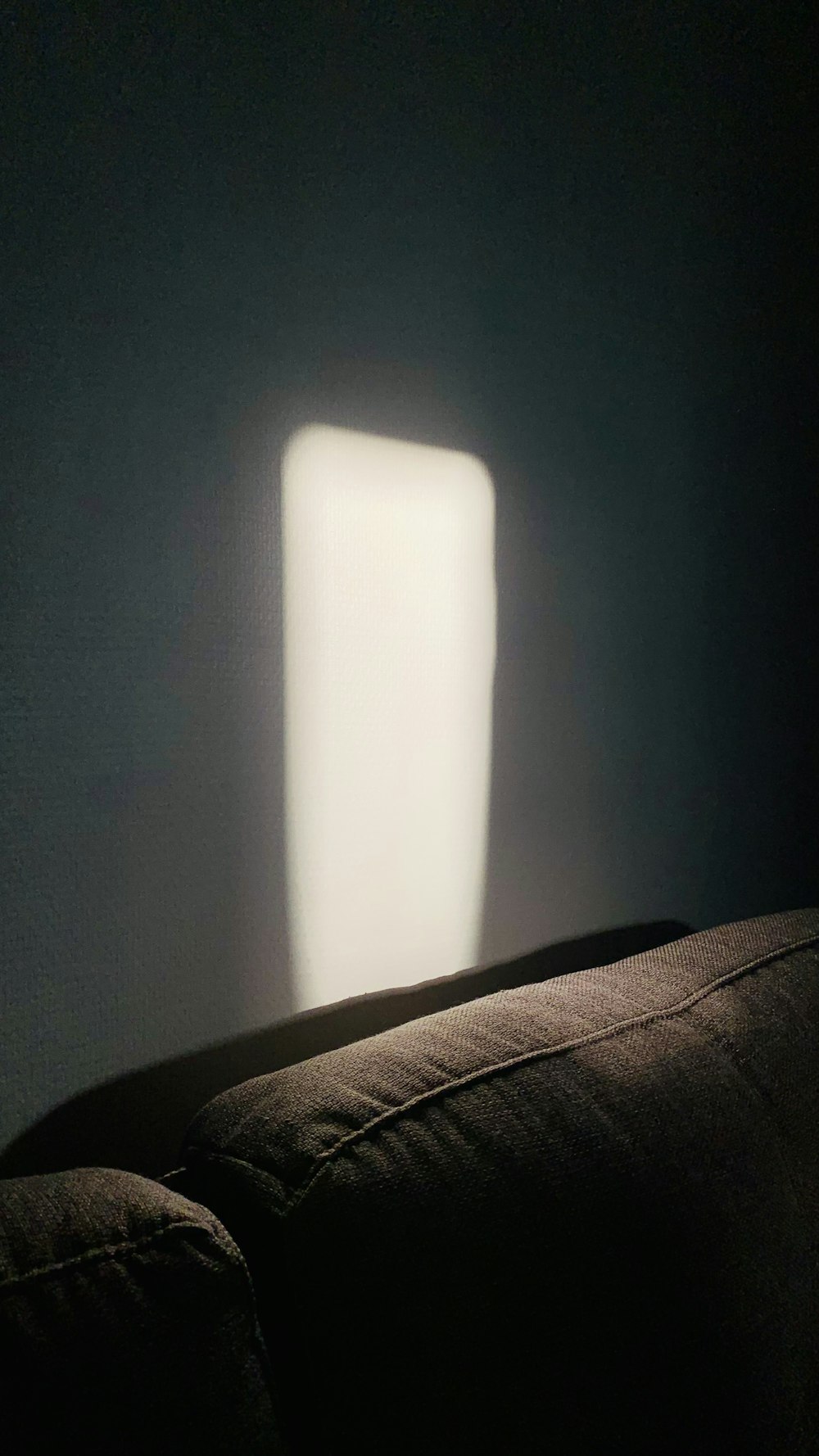 a dark room with a light coming through the window