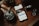A wooden surface is adorned with grooming tools including a comb, a pair of scissors, a trimmer, and a jar labeled 'Daily Grind Knuckle Cream.' A smartphone displaying a social media page for 'Daily Grind Beard Co.' is centrally placed.