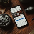 a phone sitting on top of a wooden table next to a comb