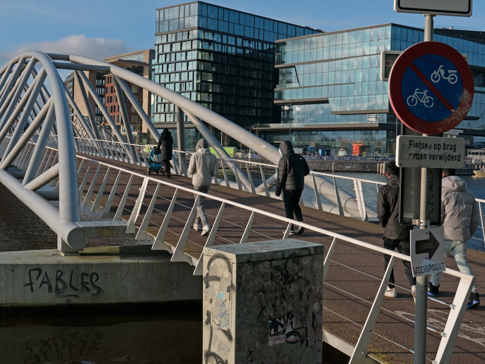 a group of people walking across a bridge