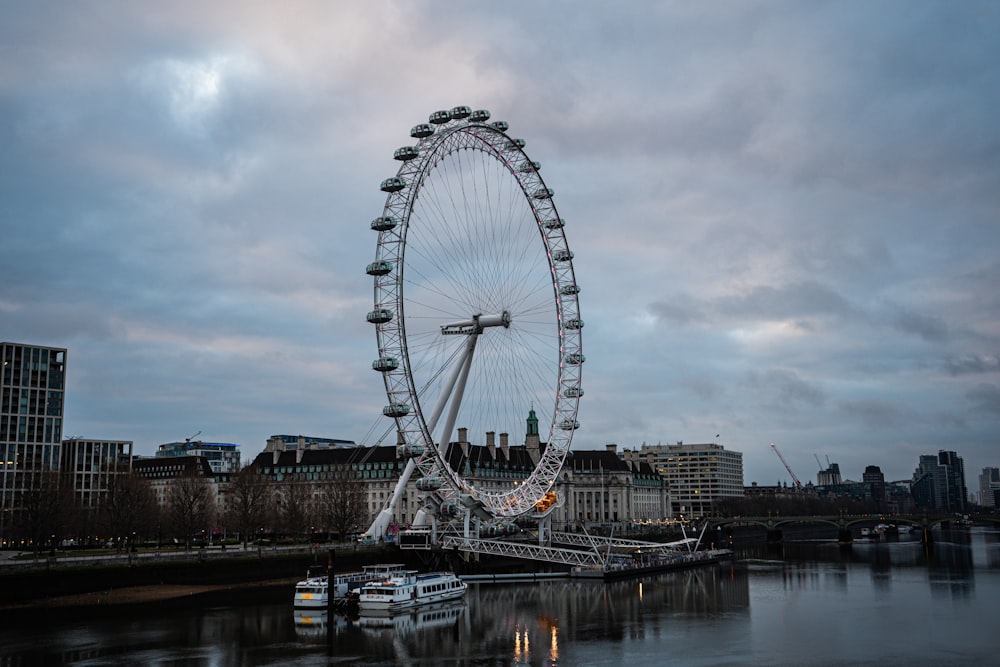 a large ferris wheel sitting on the side of a river