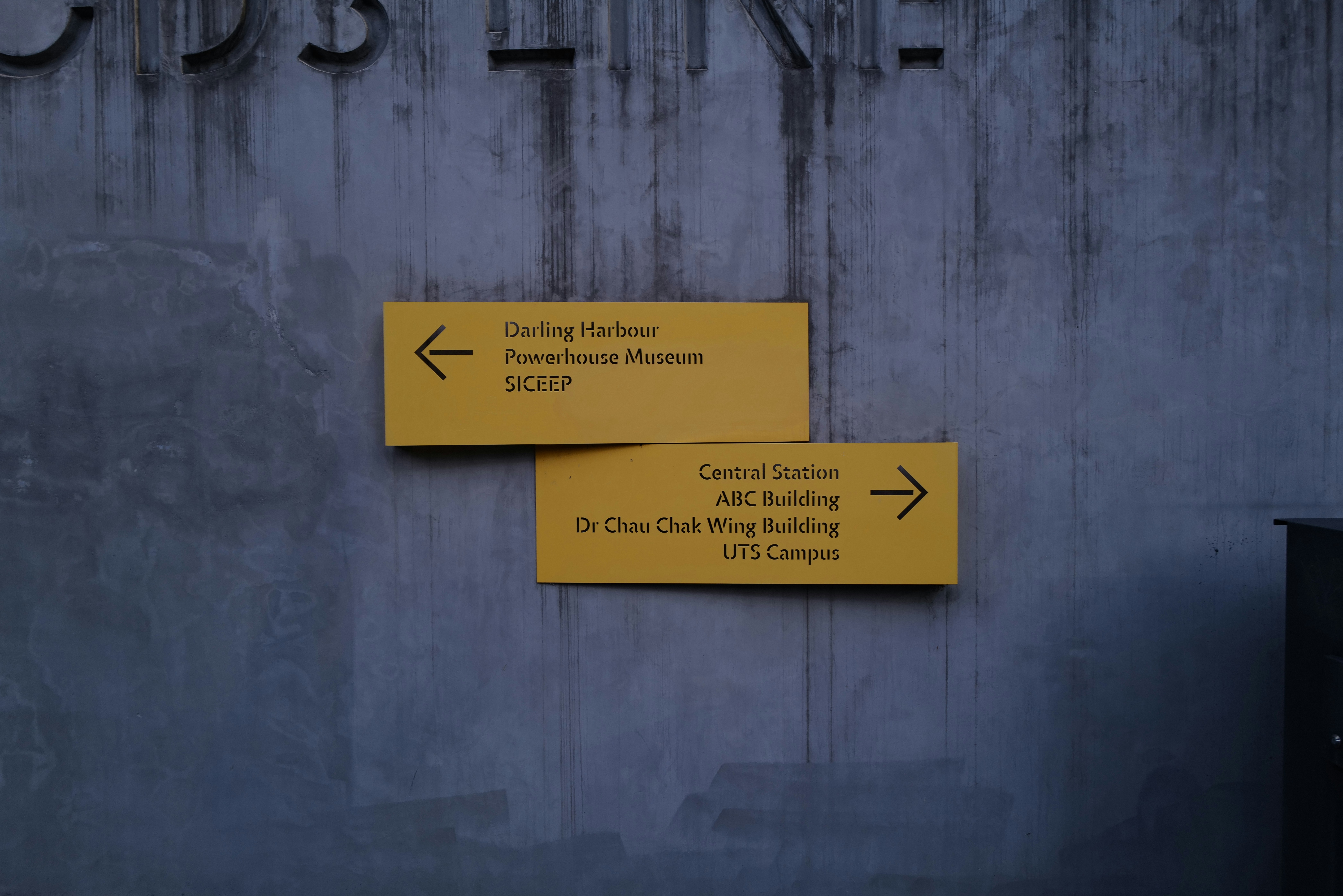 a couple of yellow signs on the side of a building