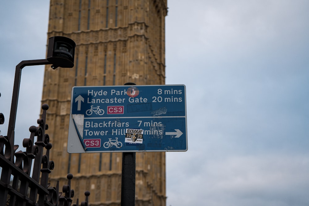 a street sign in front of the big ben clock tower