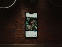 a cell phone sitting on top of a wooden table