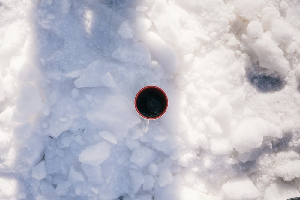 a cup of coffee sitting on top of a pile of ice