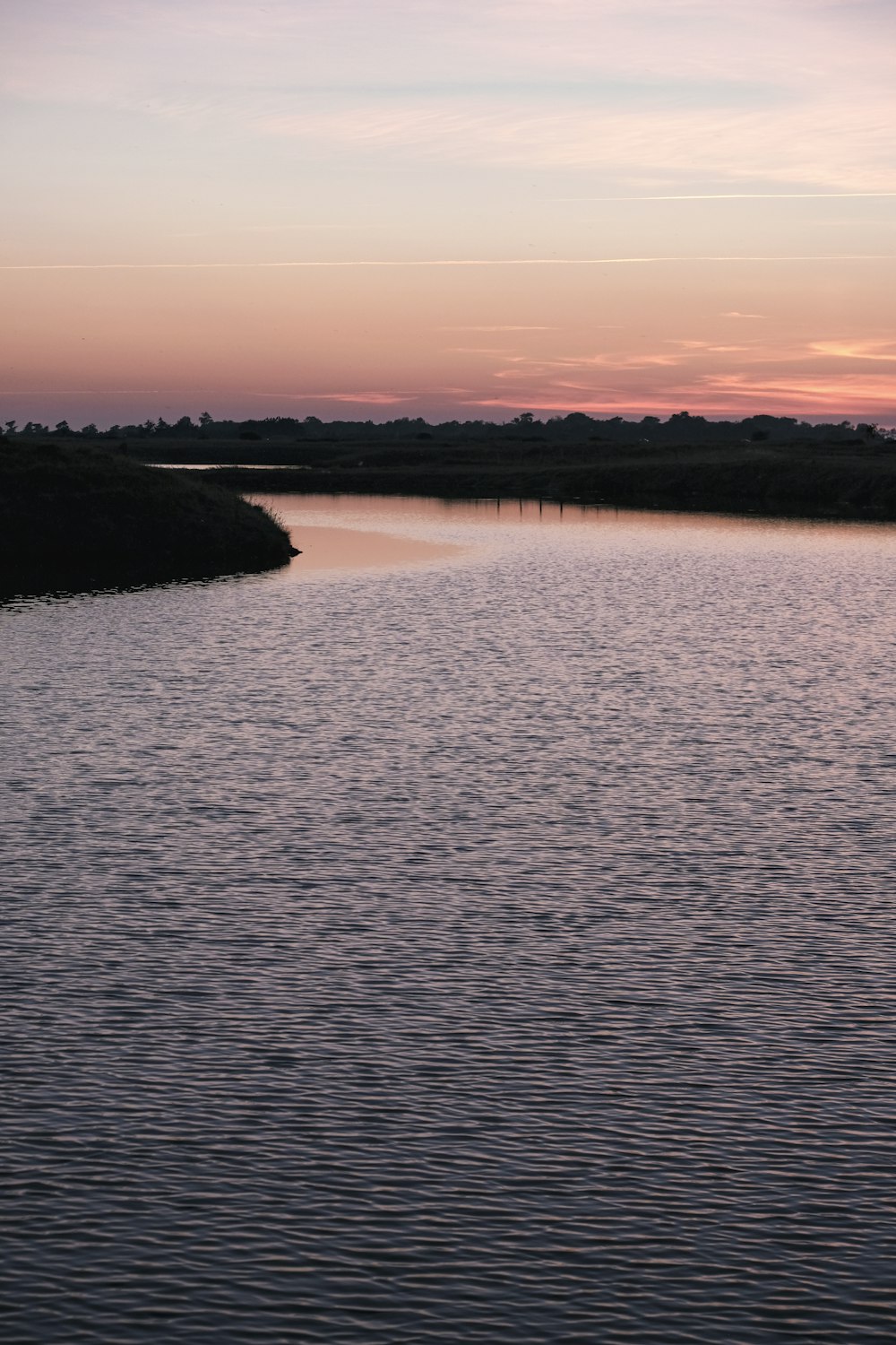 a body of water with a sky in the background