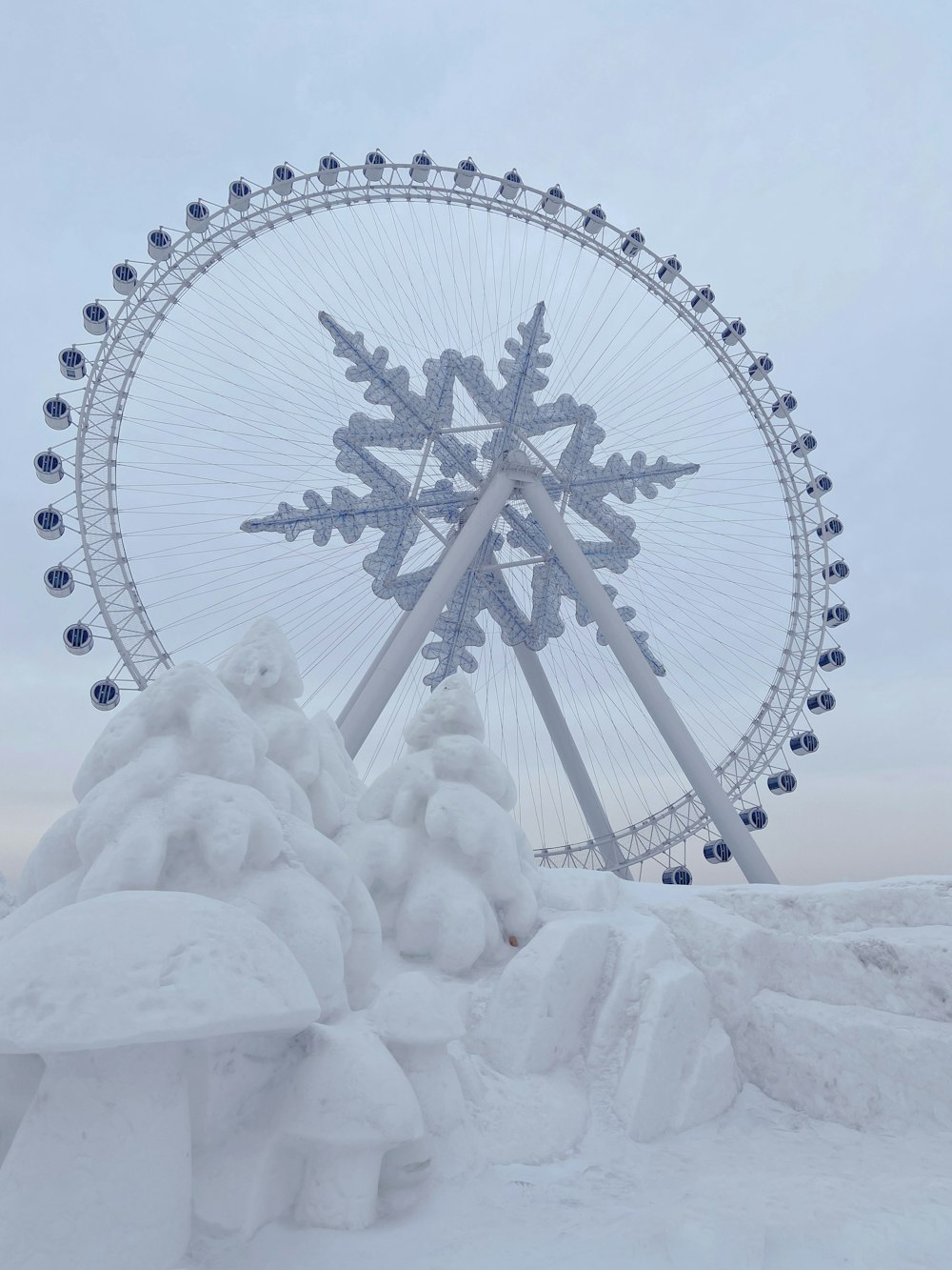 a large ferris wheel in the middle of a snowy field