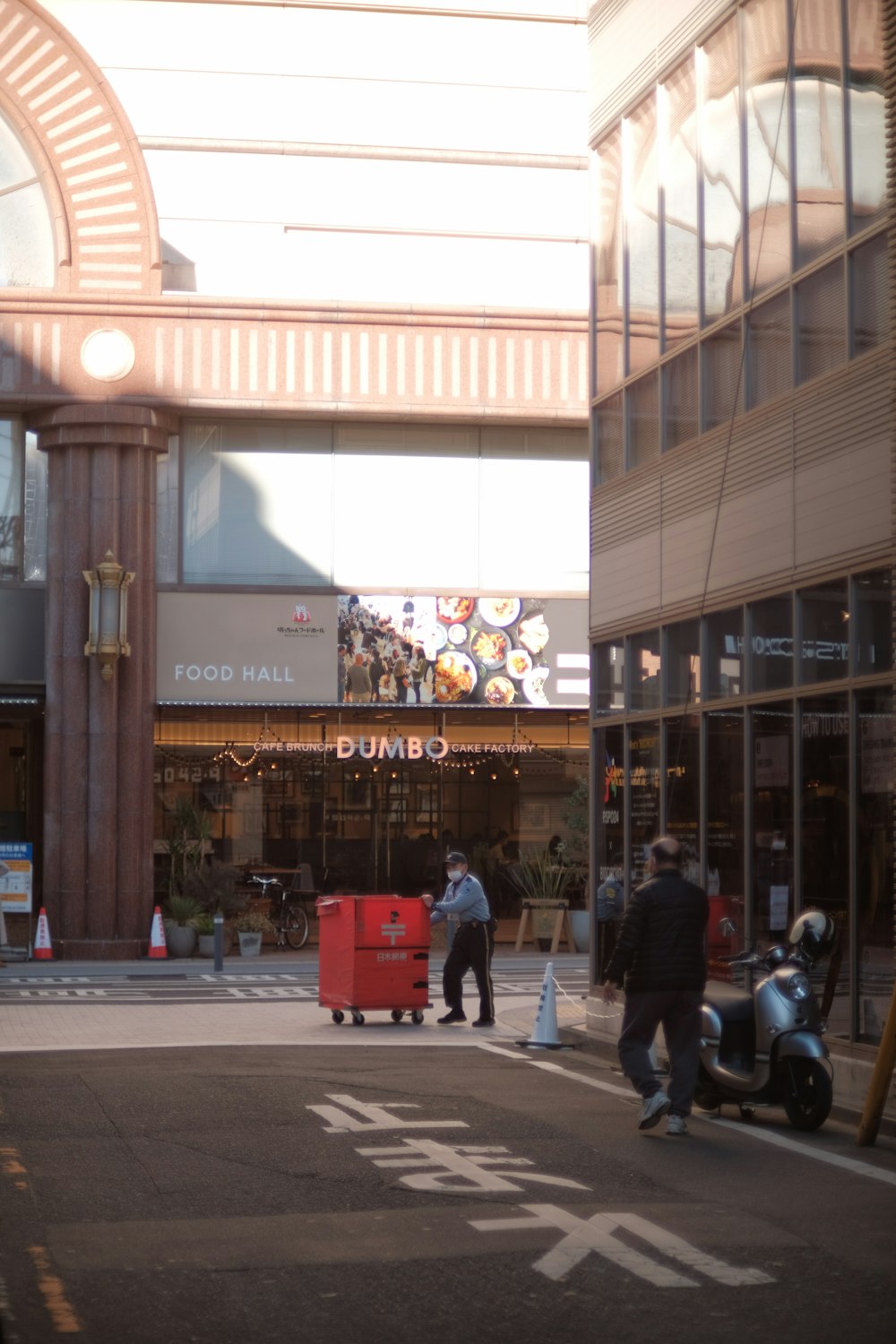 a group of people walking down a street next to tall buildings