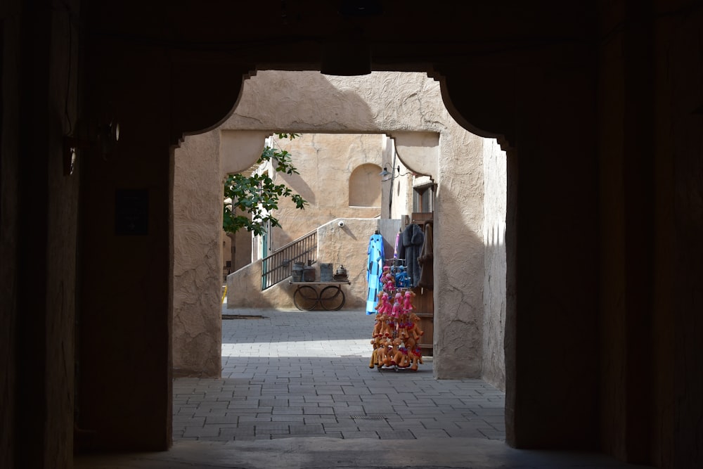 a narrow alley way with umbrellas and chairs