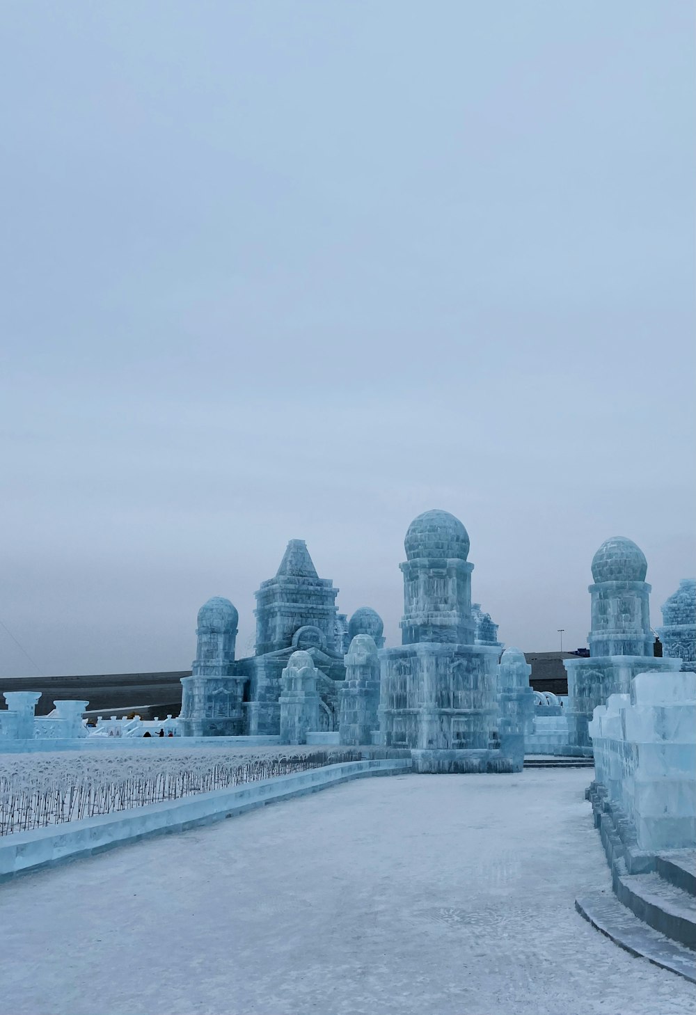 a large ice sculpture with a clock tower in the background