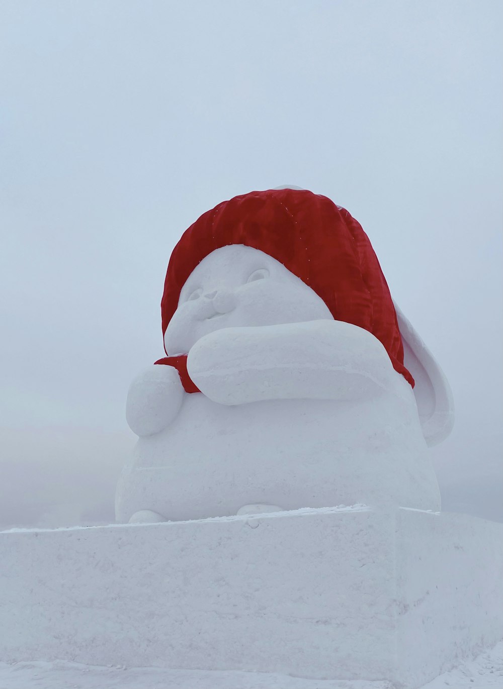 a snow sculpture with a santa hat on top of it