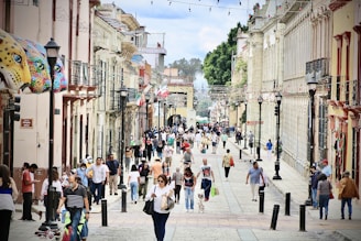 A vibrant street scene in Guadalajara's historic downtown with shops and people walking.