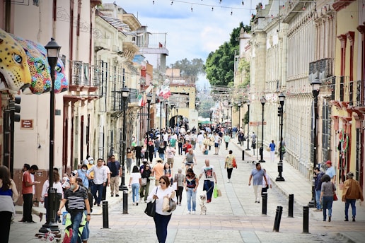 A vibrant street scene in Guadalajara's historic downtown with shops and people walking.