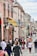 a crowd of people walking down a street next to tall buildings