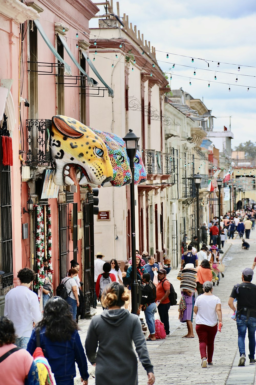 a crowd of people walking down a street next to tall buildings