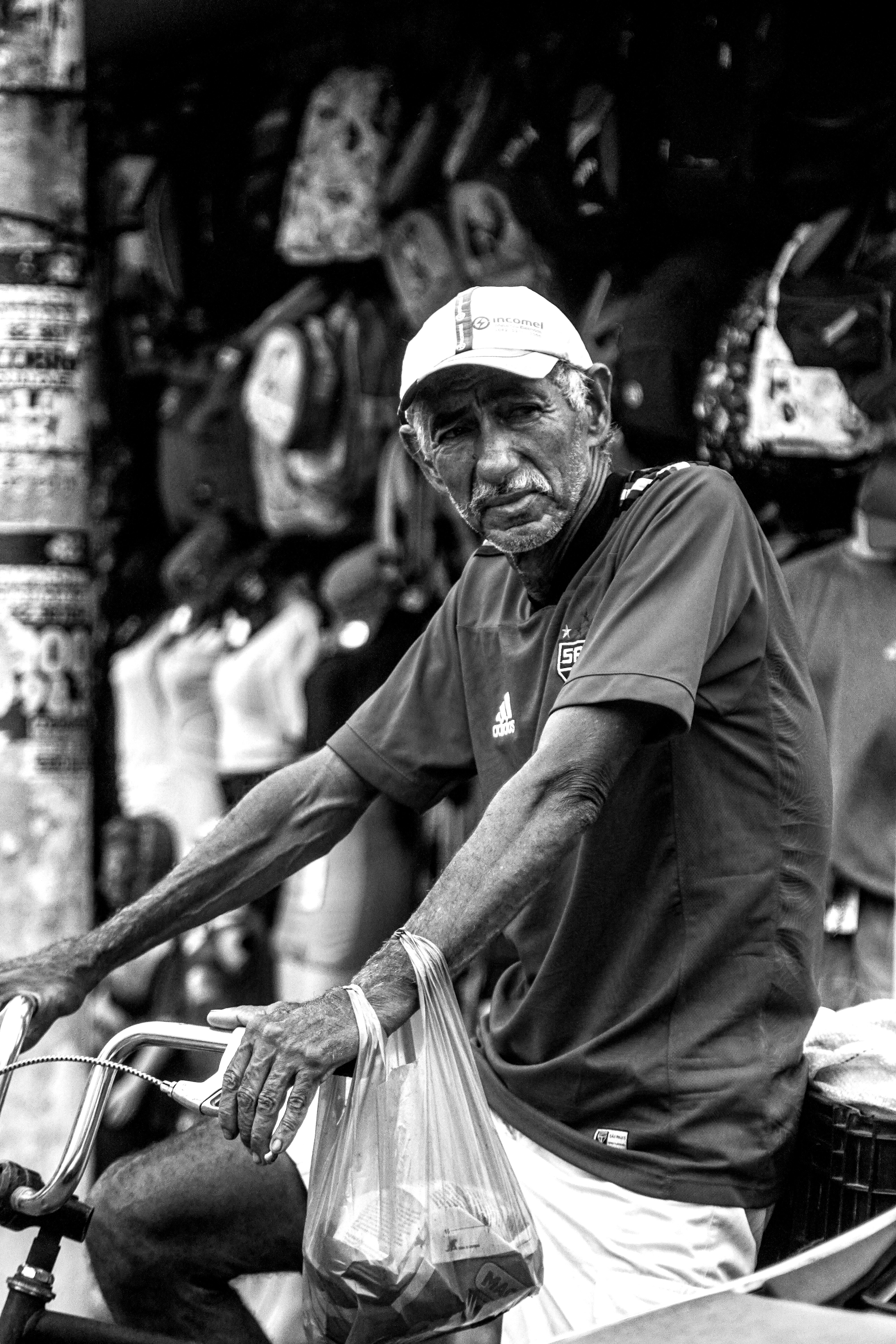 uma foto em preto e branco de um homem andando de bicicleta