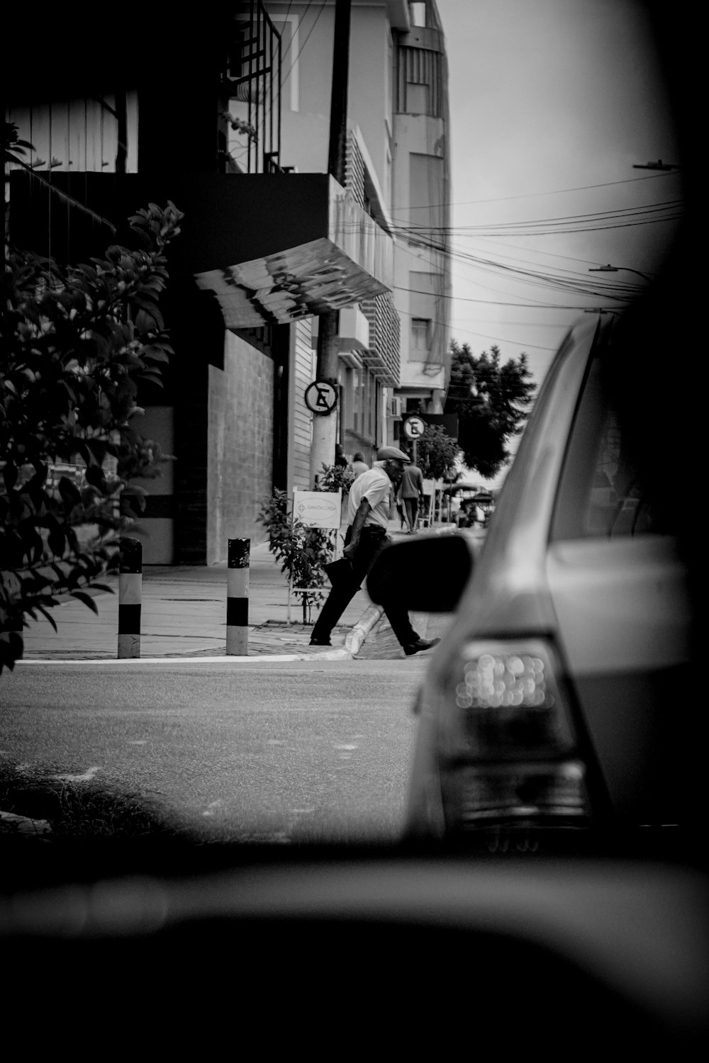 a man walking across a street next to a car