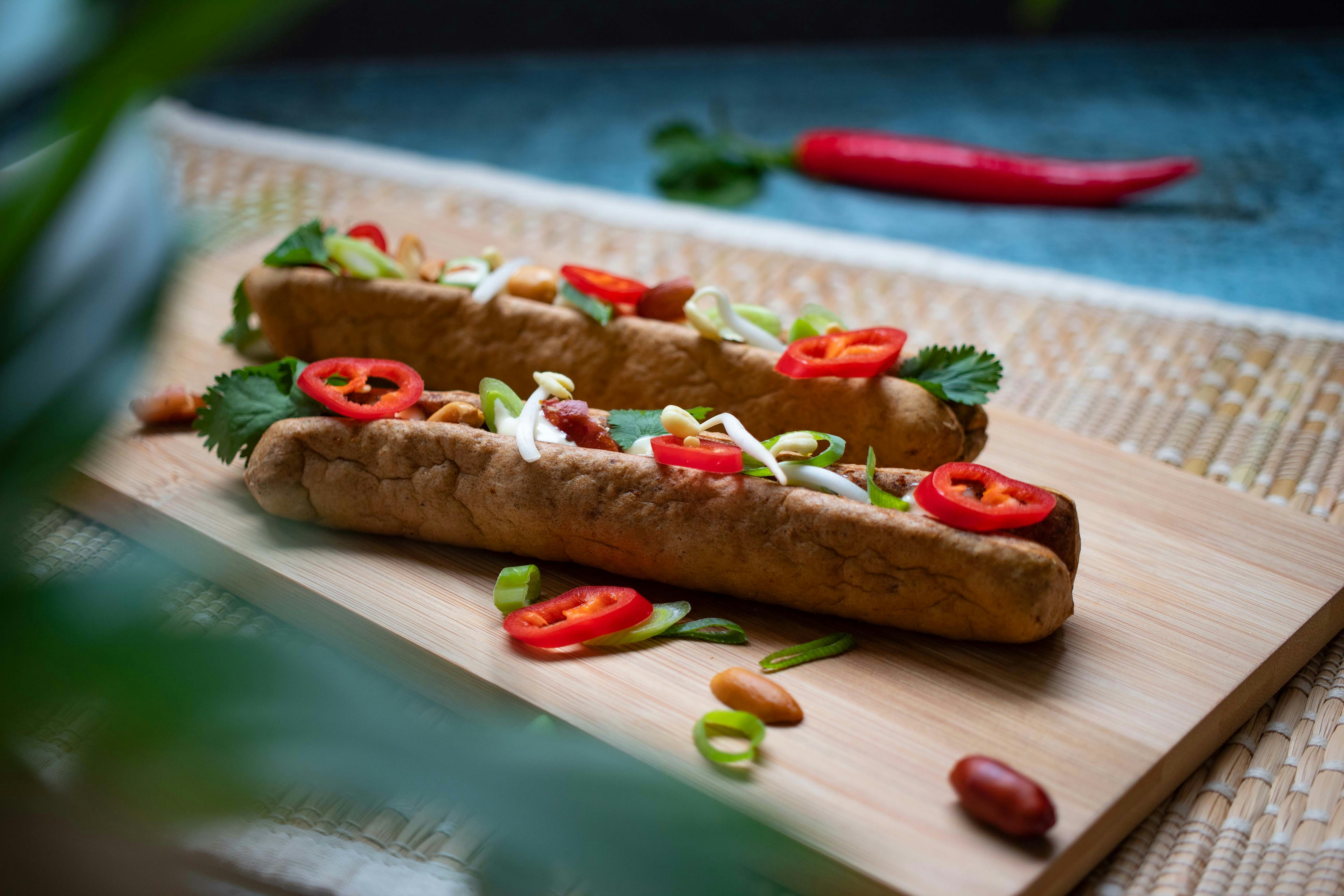 two hot dogs on a wooden cutting board
