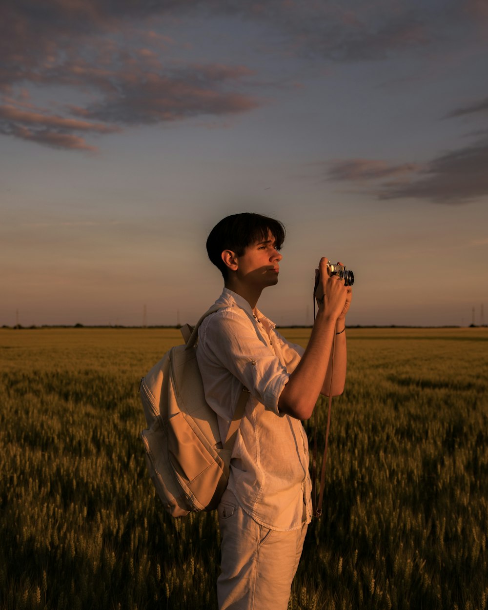 a man standing in a field holding a camera