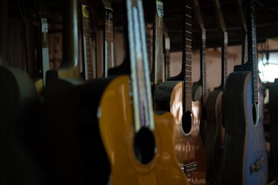 Rows of different models of wooden acoustic pianos displayed in a showroom.