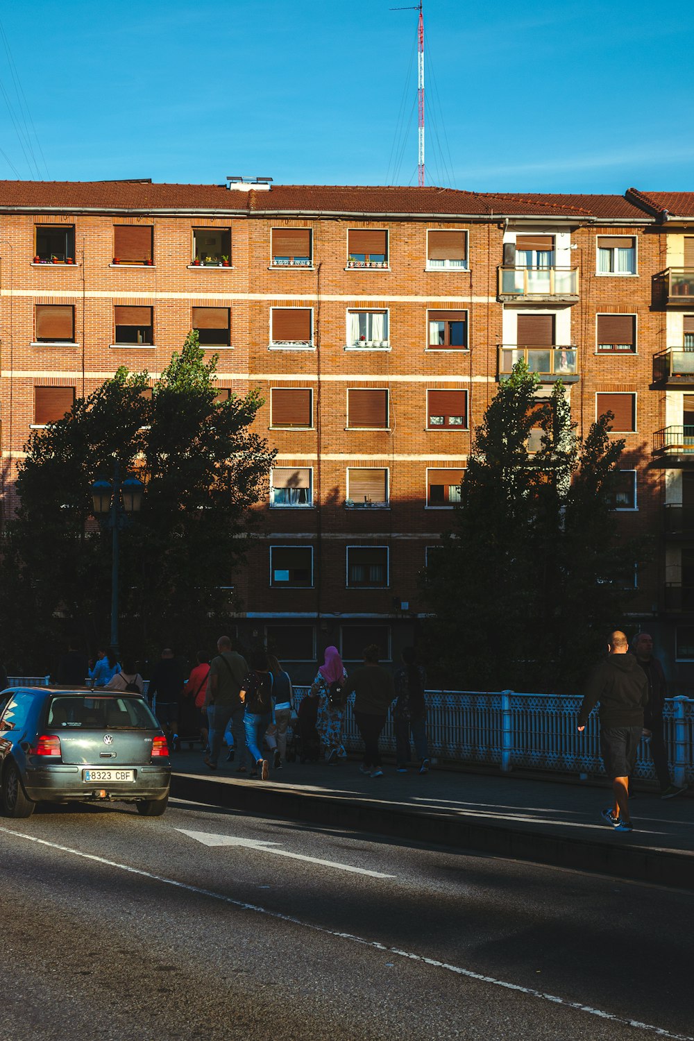 a group of people walking down a street next to a tall building