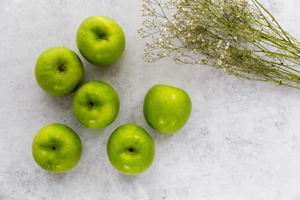 a group of green apples sitting on top of a table