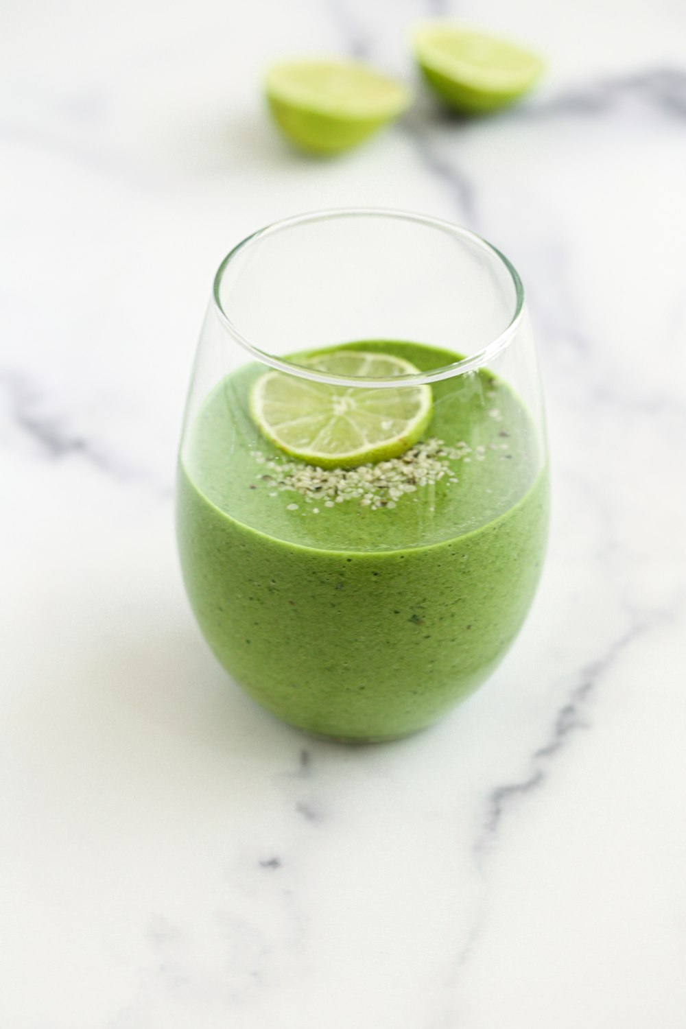 a green smoothie with a lime slice on top