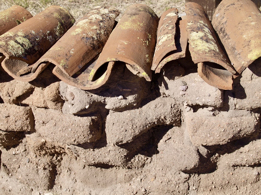 a pile of old rusty pipe laying on top of a pile of dirt