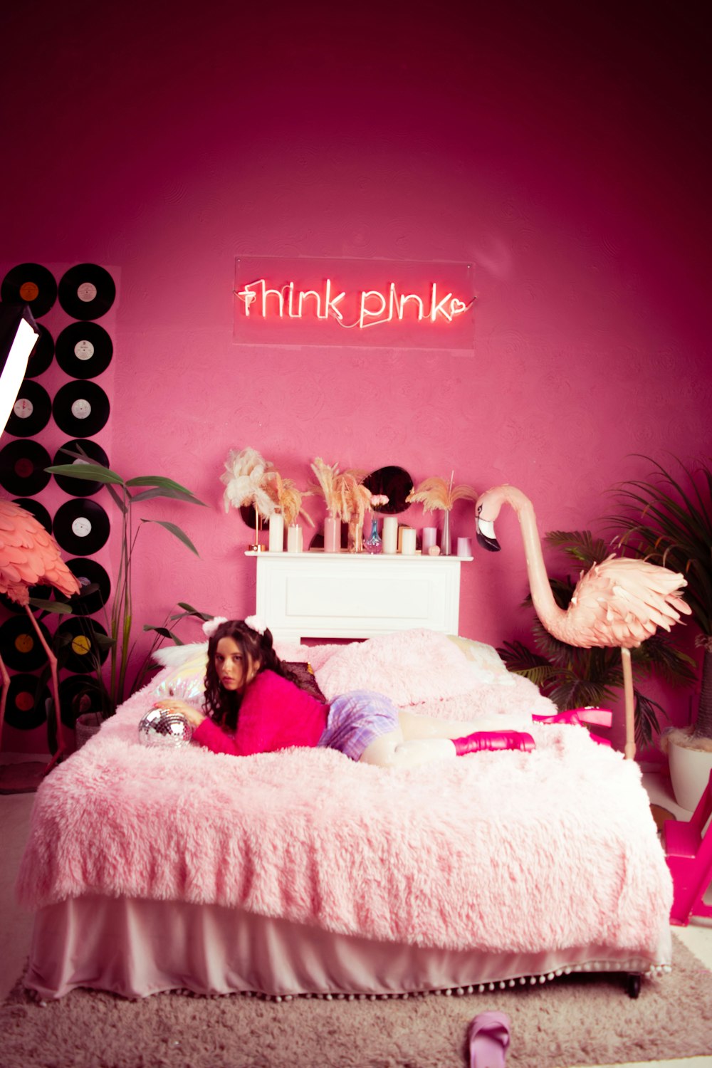 a girl laying on a pink bed in a pink room