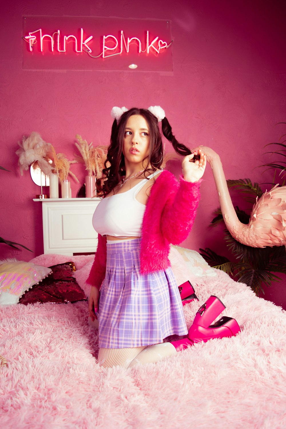 a woman sitting on a bed in a pink room