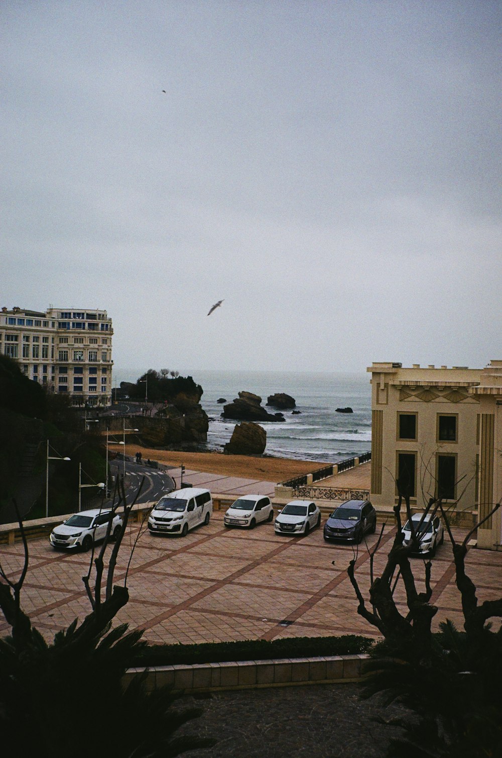 a parking lot with cars parked in front of the ocean