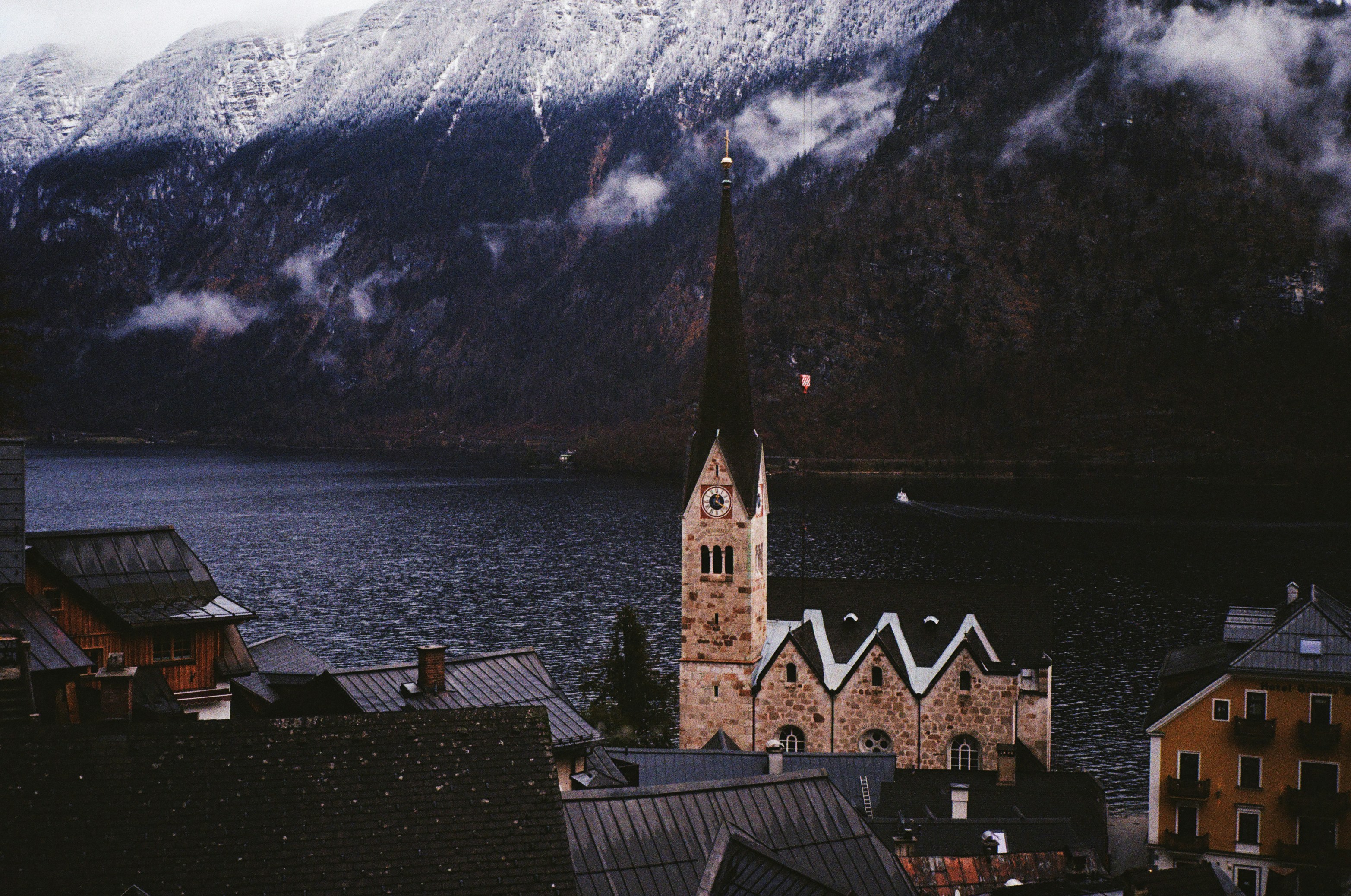 Un campanario de iglesia con una montaña al fondo