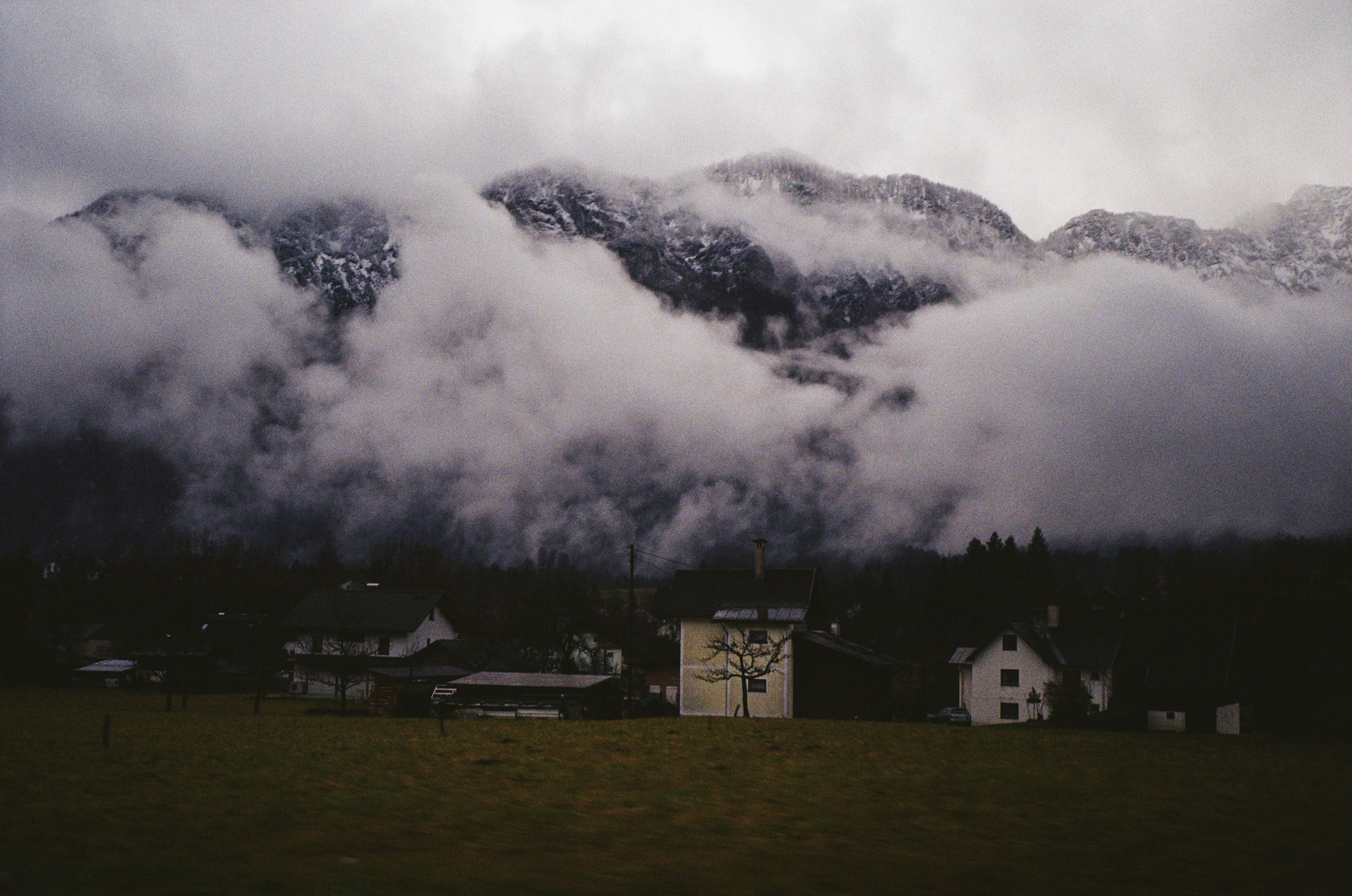 una cadena montañosa cubierta de nubes y casas