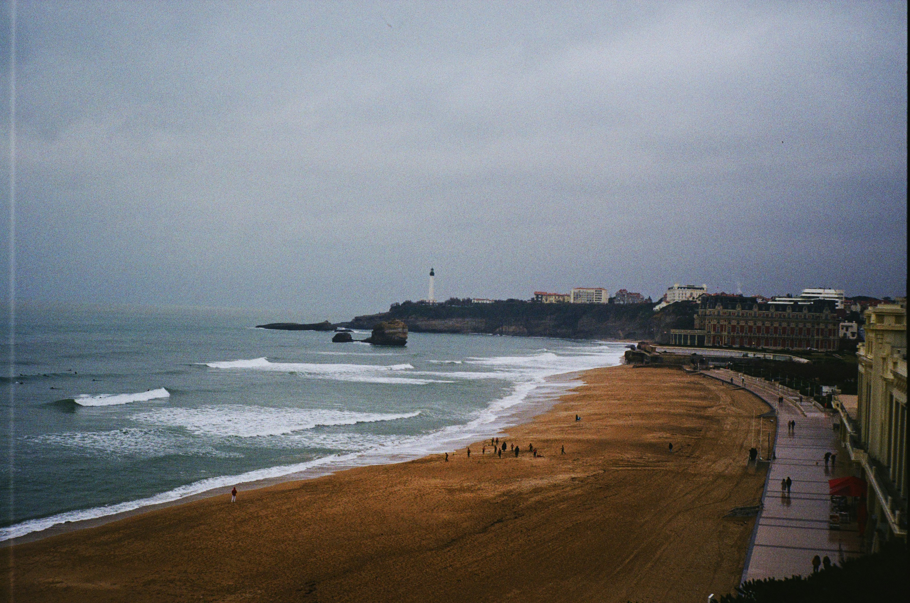 Una vista de una playa con un faro en la distancia