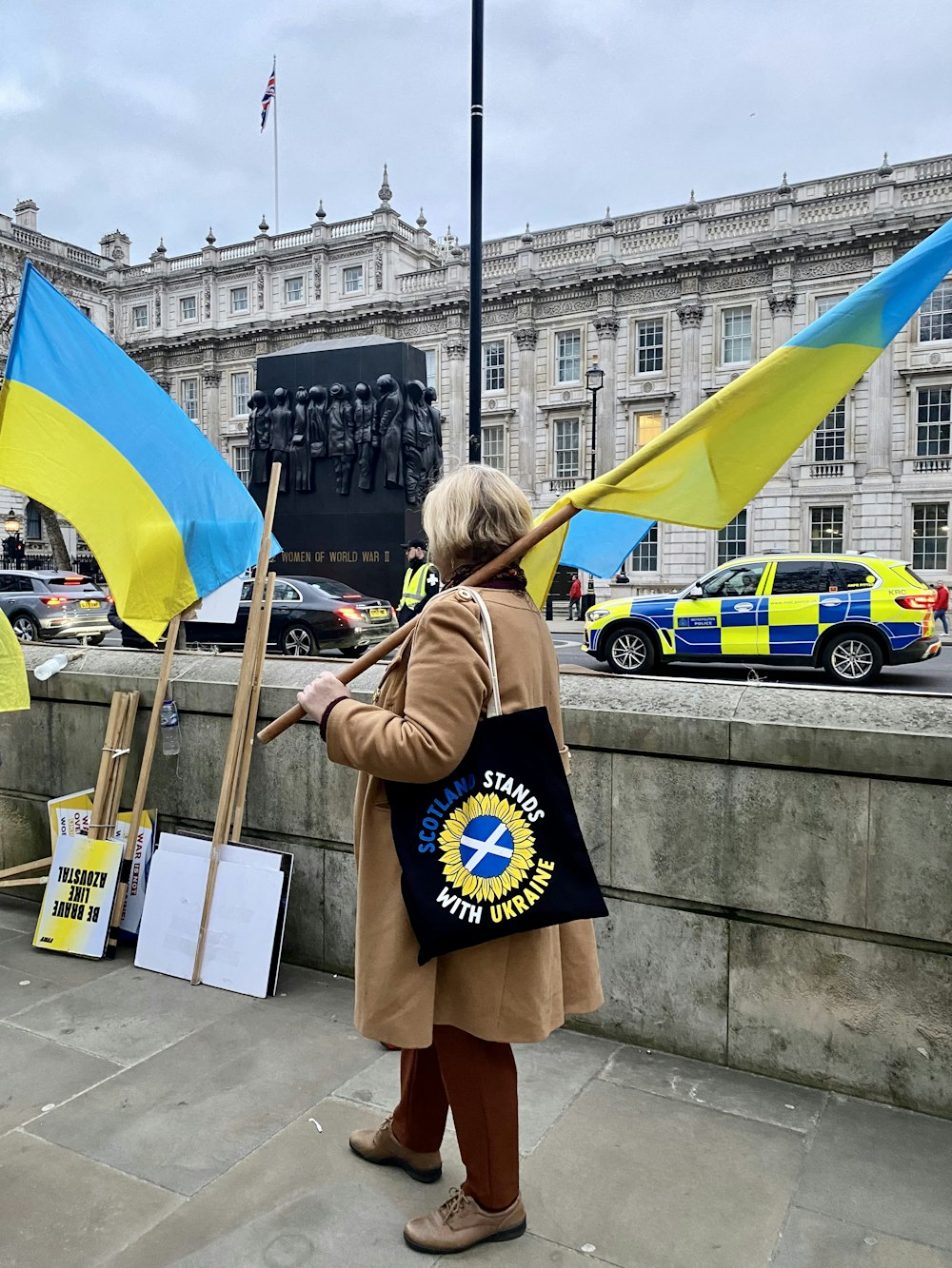 a woman holding a flag in front of a building