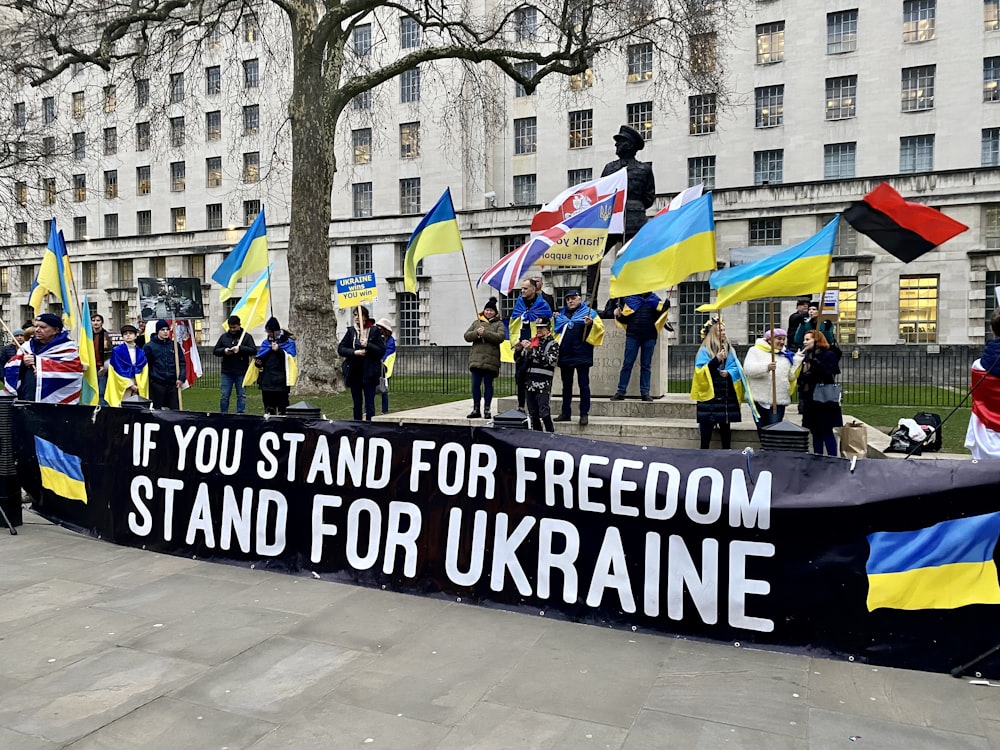 a group of people holding flags and a banner