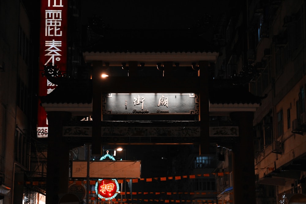 a city street at night with a lit up clock