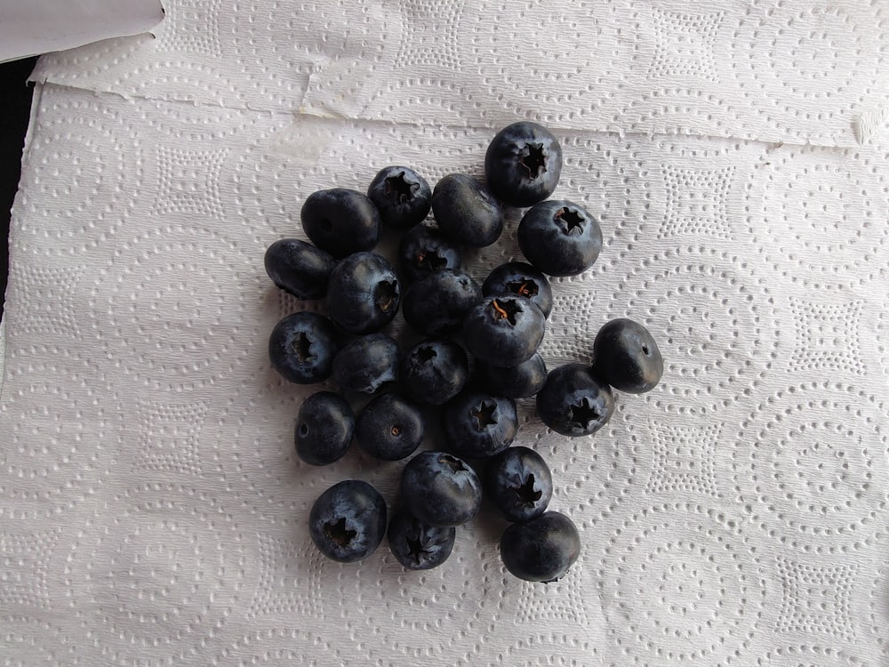 a pile of blueberries sitting on top of a white napkin