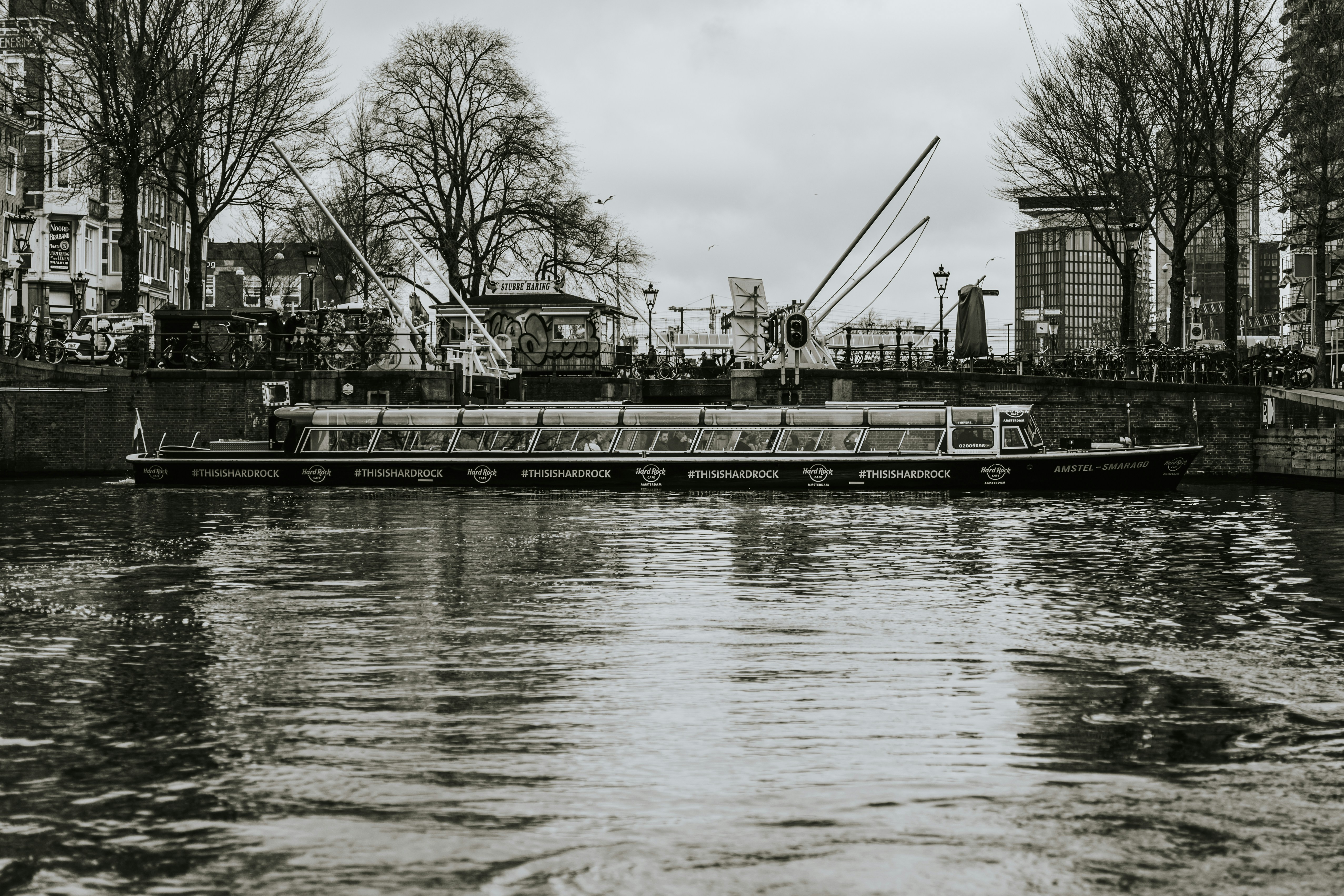 a boat floating down a river next to tall buildings