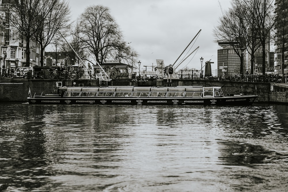 a boat floating down a river next to tall buildings