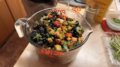 Modern glass measuring cups filled with fresh ingredients on a kitchen table