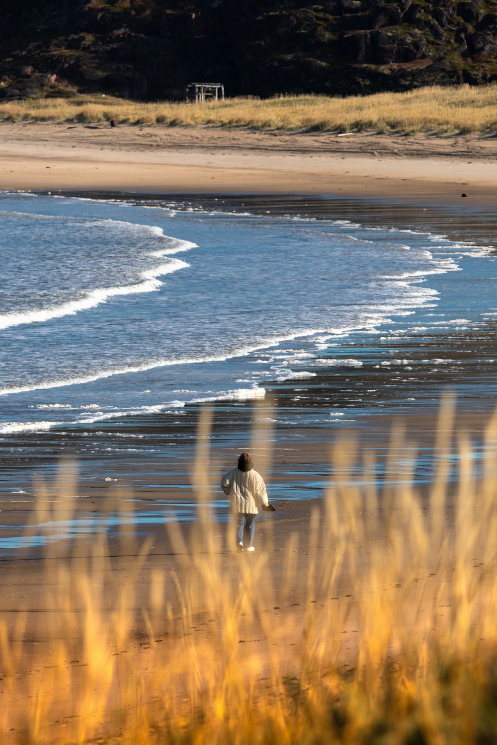 a person walking on a beach with a surfboard