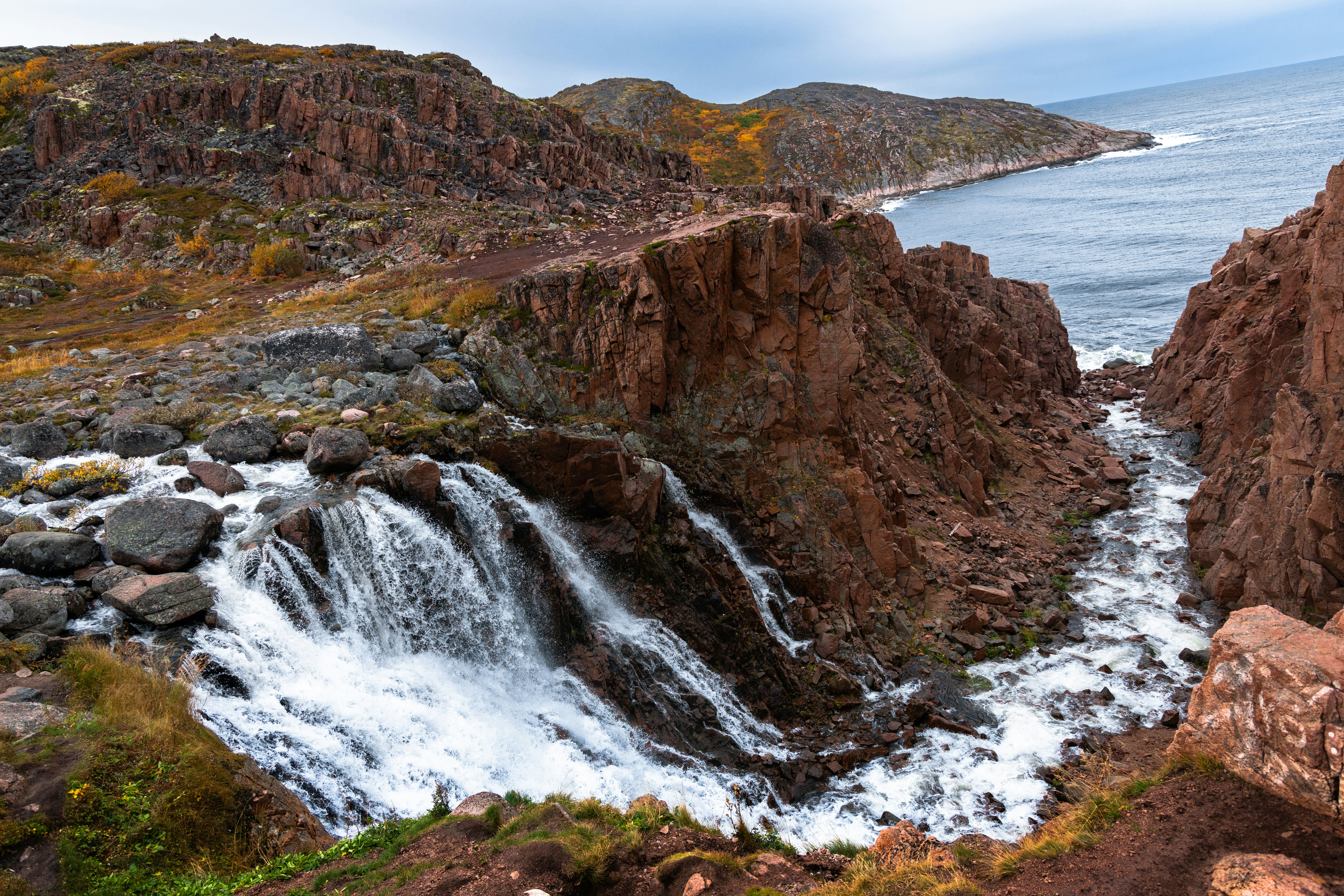 a waterfall in the middle of a rocky area, 